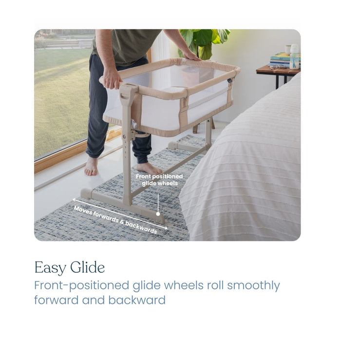 A person stands by a bed, holding the HALO 2-in-1 Bedside BassiNest Sleeper, which features breathable mesh sides and front-positioned glide wheels for smooth forward and backward movement, as shown by arrows and text in the image.