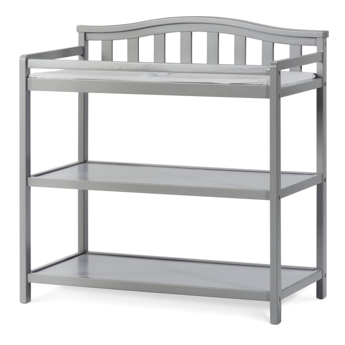 The Child Craft Arch Top Baby Changing Table in Cool Gray features two open shelves and a curved slatted backrest, displayed on a white background.