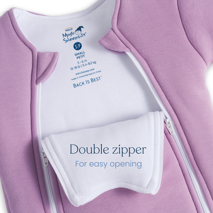 A close-up of HALO Baby Merlin's Magic Sleepsuit® 100% Cotton in pink, size small/petite, shows two zippers partially open to reveal a white inner flap for easy access—ideal for swaddle transition and better baby sleep.