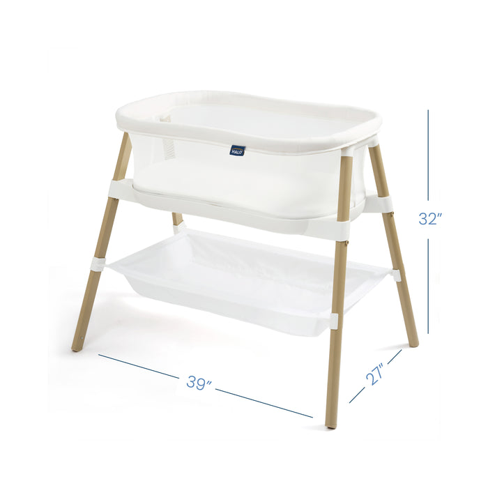 The HALO BassiNest® Essential Sleeper is a white baby bassinet with a sturdy wooden frame, mesh walls, and a handy lower storage shelf. It measures 39 L x 27 W x 32 H, providing a portable and convenient sleep space.