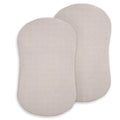 Two light beige, oval-shaped HALO BassiNest® Fitted Sheets (2-pack) crafted from 100% organic cotton with subtle vertical stripes, shown overlapping on a white background—ideal for newborns and gentle comfort.