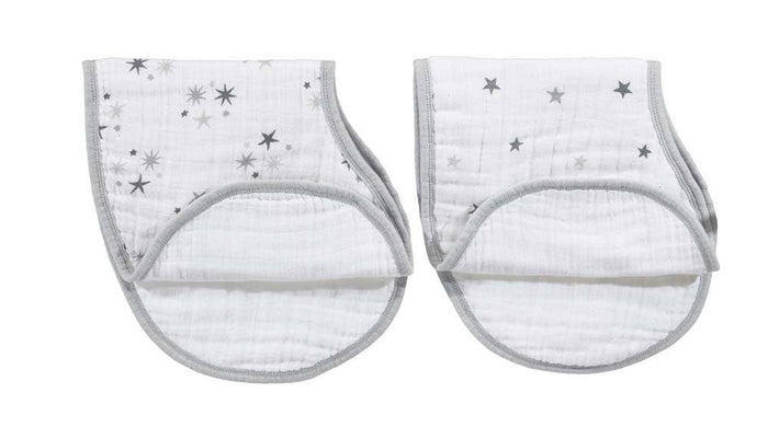 The image shows two aden + anais burpy bibs from the boutique 100% cotton muslin 2-pack: white with gray star patterns, featuring a patented design, absorbent muslin fabric, a rounded shape, and gray edging.