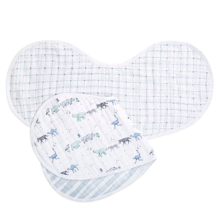 Two aden + anais boutique 100% cotton muslin burpy bibs are shown: one with a blue and green animal pattern featuring elephants and giraffes, and the other with a white and blue plaid design. Both have absorbent muslin, a soft contoured shape, and white edging for perfect coverage.