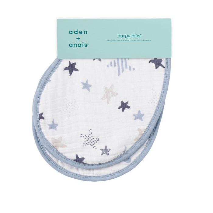 A pair of aden + anais boutique 100% cotton muslin burpy bibs, featuring a star pattern in blue and beige with light blue trim, displayed with packaging showcasing the brands patented design.