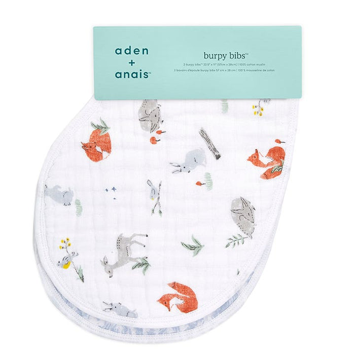 A white Boutique burpy bib from aden + anais, patterned with pastel woodland animals like foxes, rabbits, and deer, offers a luxurious finish with absorbent muslin. The blue-green label highlights the brand name and product details.