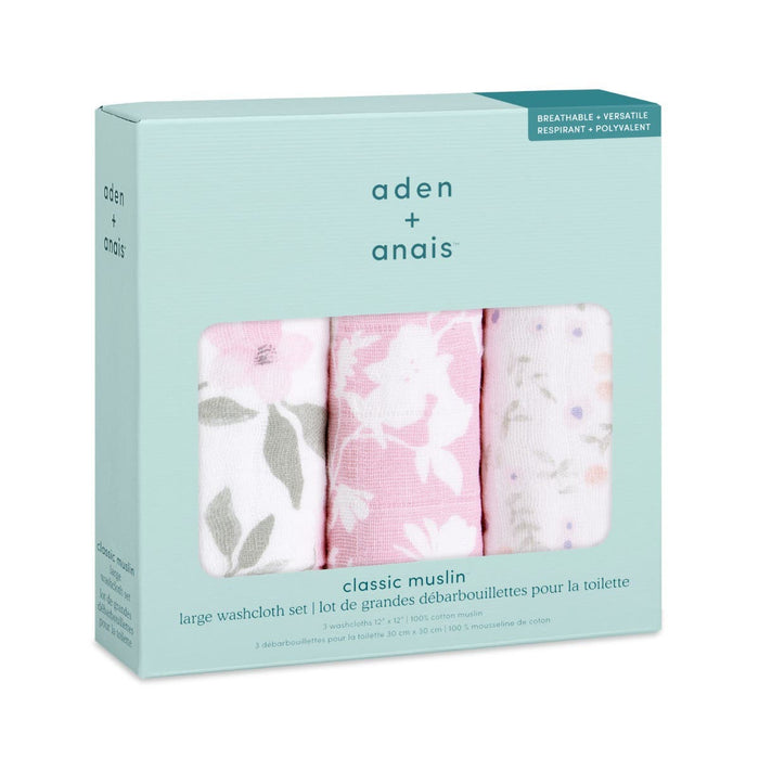 The aden + anais boutique pack includes three oversized 100% cotton muslin washcloths, ideal for delicate skin. Featuring floral and bird patterns in pink and white, these breathable and absorbent items are versatile essentials.