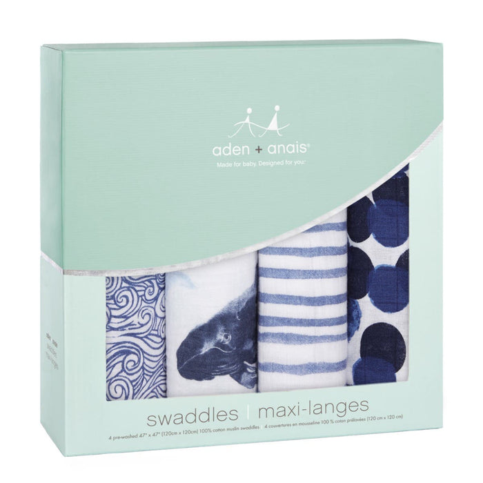 A 4-pack of aden + anais boutique 100% cotton muslin swaddle blankets with designs of ocean waves, a whale, blue stripes, and polka dots. Renowned for their absorbency and breathability, they come in light green packaging with white and blue text.
