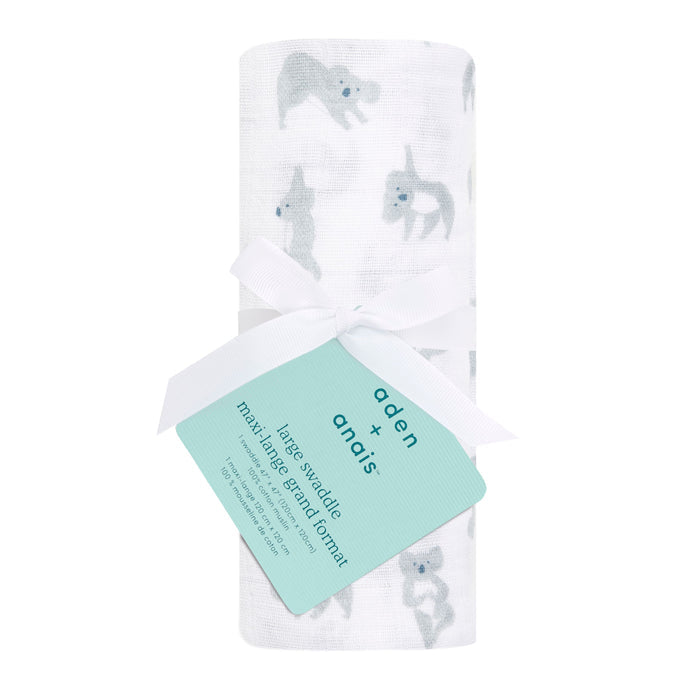 A rolled aden + anais boutique 100% cotton muslin swaddle blanket features a delicate light gray animal pattern on white and is tied with a white ribbon, featuring a green label—an essential diaper bag superhero for any outing.