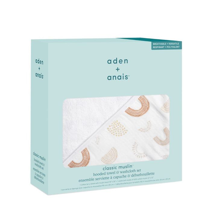 The aden + anais boutique set, featuring a hooded towel and washcloth in light blue packaging with a clear window, is crafted from 100% breathable cotton muslin. The white fabric is enhanced by pastel arches for versatile charm.