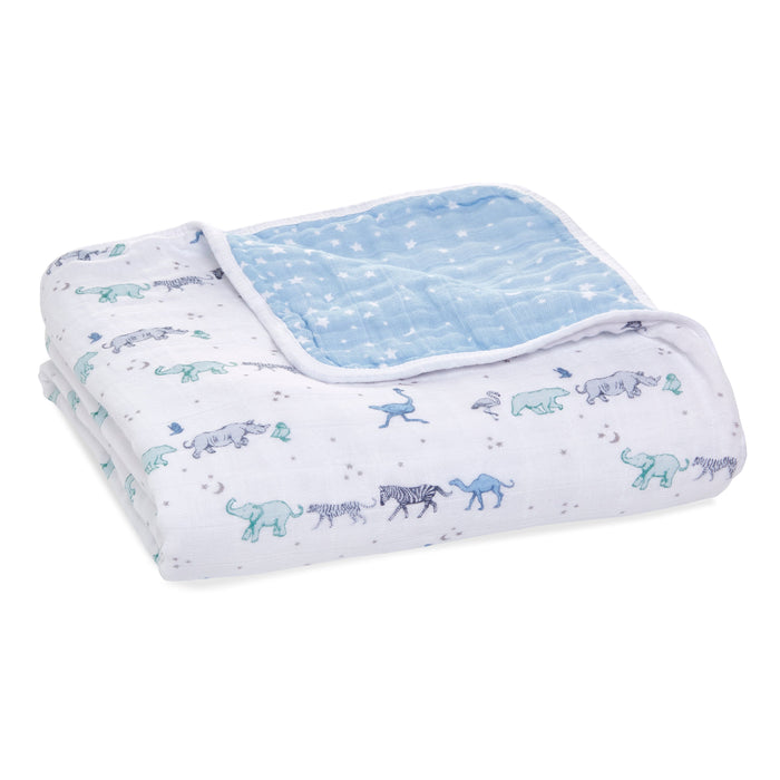 The aden + anais boutique cotton muslin dream blanket offers cozy comfort with a light blue quilted side and a white side showcasing pastel elephants, giraffes, and zebras. Made from breathable cotton muslin, its ideal for wrapping your little one.