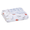 The aden + anais boutique cotton muslin dream blanket displays a charming woodland animal print featuring foxes, squirrels, and rabbits on a white backdrop. Made from breathable cotton muslin, it has a light blue underside with a delicate white pattern, ideal for nurturing cozy dreams.