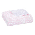 The aden + anais boutique cotton muslin dream blanket, crafted from cozy cotton muslin, features a soft floral pattern in pink and white with flowers and leaves for a delicate cloud-like appearance.