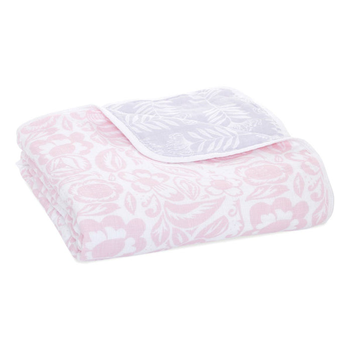 The aden + anais boutique cotton muslin dream blanket, crafted from cozy cotton muslin, features a soft floral pattern in pink and white with flowers and leaves for a delicate cloud-like appearance.