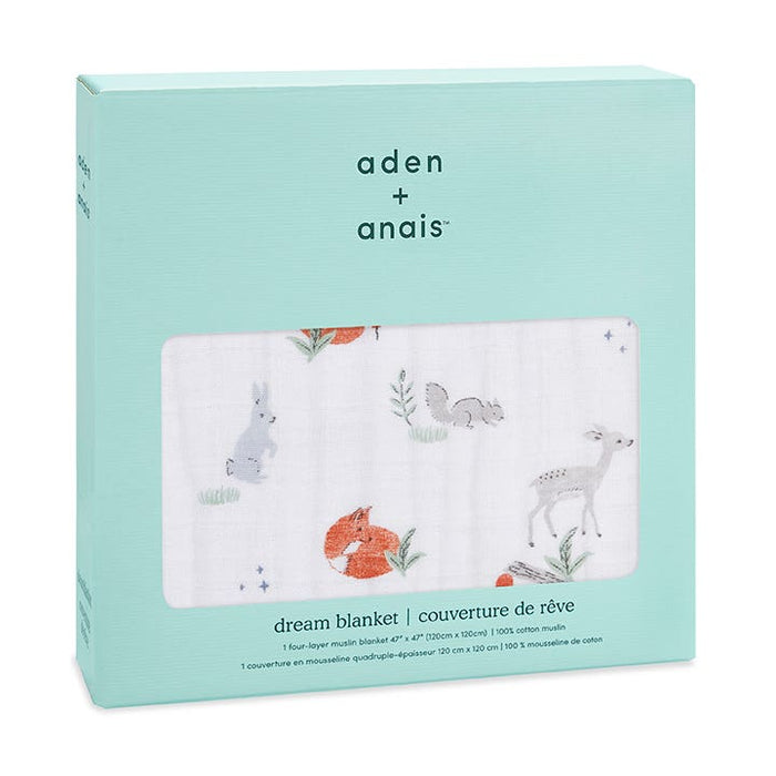 A mint box contains the aden + anais boutique cotton muslin dream blanket. This breathable, four-layer cotton muslin showcases illustrations of a fox, deer, rabbit, and squirrel. Labels in English and French emphasize its 100% cotton composition.
