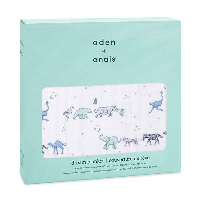 The aden + anais boutique cotton muslin dream blanket showcases charming blue and green animal illustrations, like elephants and zebras, on a white background. Made from breathable cotton muslin for extra softness, it comes in light blue packaging with branding and product details.