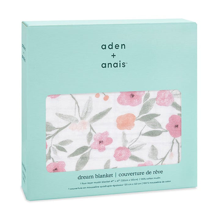 A mint green box contains the aden + anais boutique cotton muslin dream blanket. The soft, 100% cotton blanket, visible via a window, displays a floral pattern with pink and orange flowers and green leaves. The package features text in English and French.