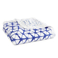 The aden + anais boutique silky soft muslin dream blanket has a silky texture with a white base and blue geometric lattice pattern.