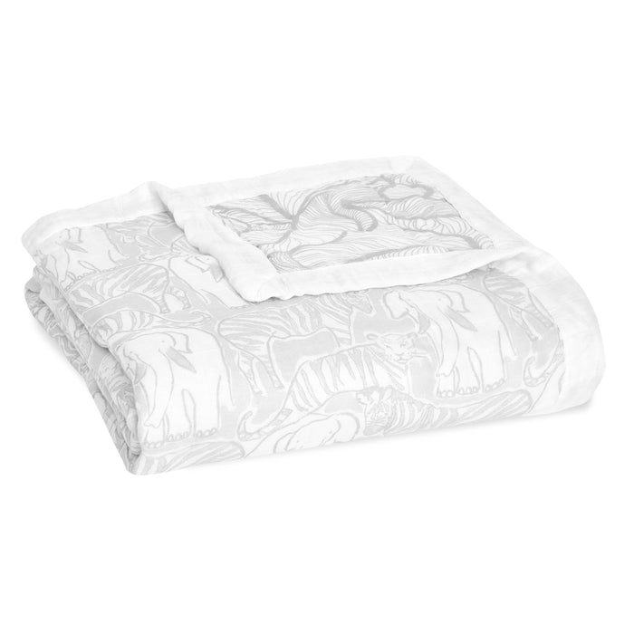 The boutique silky soft muslin dream blanket by aden + anais is a white bamboo-infused viscose blanket with gray elephants in various poses, adding a cozy and decorative touch.