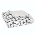 A folded aden + anais boutique silky soft muslin dream blanket features a black and white geometric pattern on a light background, set against a plain white backdrop.