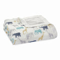 The boutique silky soft muslin dream blanket by aden + anais is folded white with animal patterns, including elephants and giraffes, in blue, gray, and yellow. This ultra-smooth blanket features a textured gray square in one corner.
