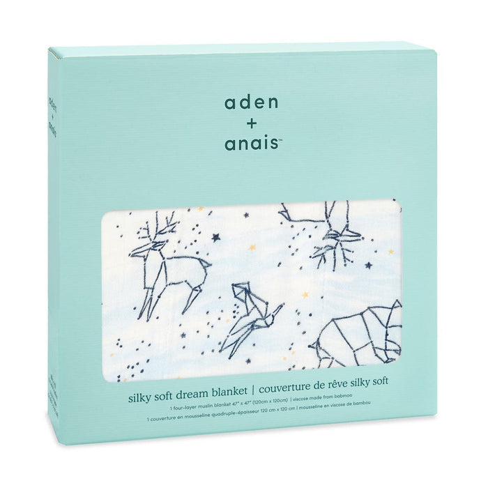 The light teal box displays an aden + anais boutique silky soft muslin dream blanket made from bamboo-infused viscose for extra comfort, featuring deer, origami birds, and stars on a white background. It includes product details in multiple languages.