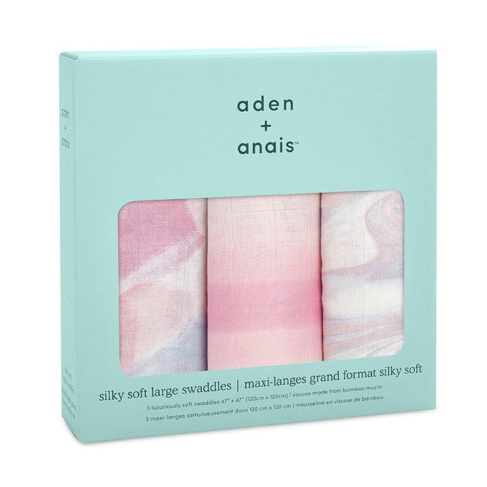 A teal box holds the boutique silky soft swaddle blanket 3 pack by aden + anais. Made from bamboo-infused viscose, these 47 x 47 swaddles offer remarkable breathability and display partial pastel patterns in pink and blue hues.