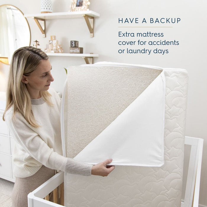 A woman holds a HALO DreamWeave Breathable Crib Cover, illustrating its mattress protection. With the cover folded back to show its breathable texture, the room features baby decor. Text: HAVE A BACKUP. Extra hypoallergenic cover for accidents or laundry days.