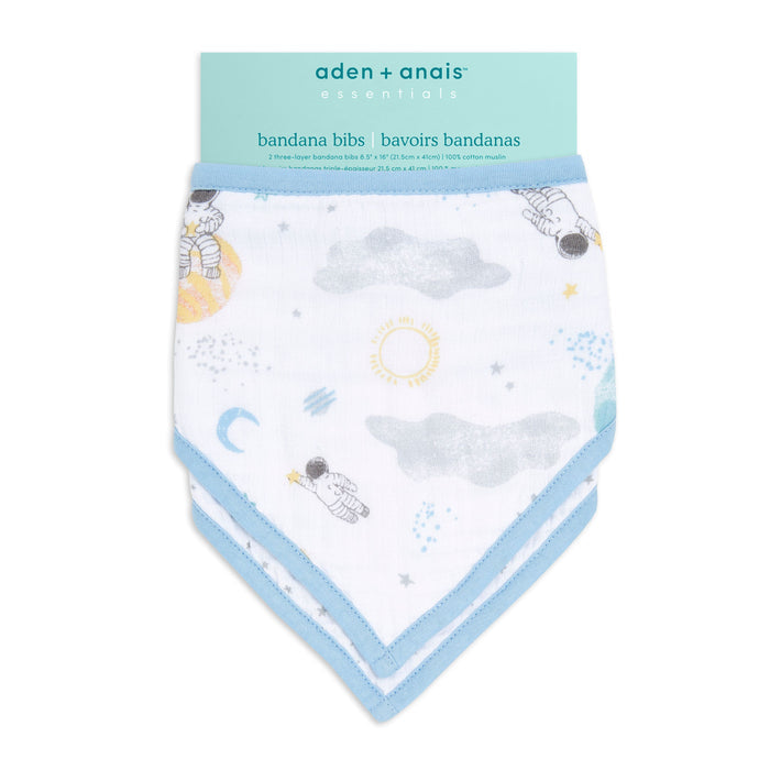 The aden + anais essentials white cotton muslin bandana bib has blue trim, adjustable fit, and a delightful pattern of astronauts, stars, clouds, sun, and moon.