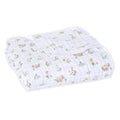 The aden + anais essentials cotton muslin dream blanket, in white, unfolds a warm and cozy ambience with a delightful floral and animal print of delicate pink flowers on textured cotton muslin.