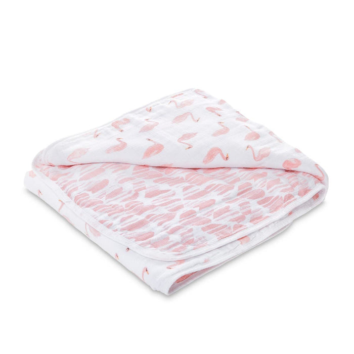 The aden + anais essentials cotton muslin dream blanket is a snug, warm, and absorbent blanket featuring pink flamingos on one side and abstract brush strokes on the other, wrapping your baby in comfort.