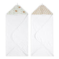 The aden + anais essentials cotton muslin hooded towels 2 pack includes two white towels: one with green elephants and another with a beige zigzag, made from plush cotton terry for maximum absorbency. Both offer cozy corners ideal for wrapping up little ones.