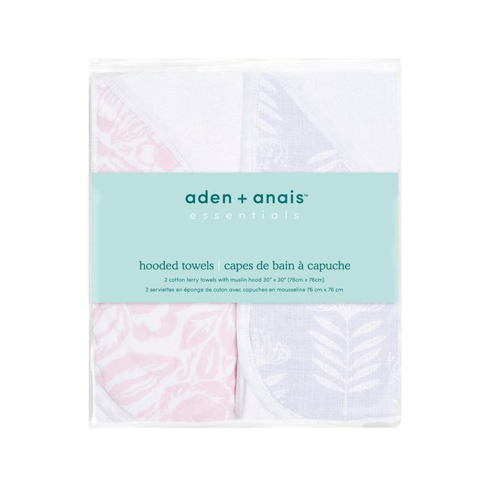 The aden + anais essentials cotton muslin hooded towels 2 pack offers two super absorbent designs: one with pink patterns and another with blue leaf motifs. Made from plush cotton terry, the packaging features labels in English and French.
