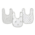 Three essentials cotton muslin snap bibs from aden + anais are shown, crafted from absorbent cotton muslin. Each light-colored bib has gray trims: one is plain, another with gray stars, and the third has gray polka dots, designed for growing convenience and comfort.