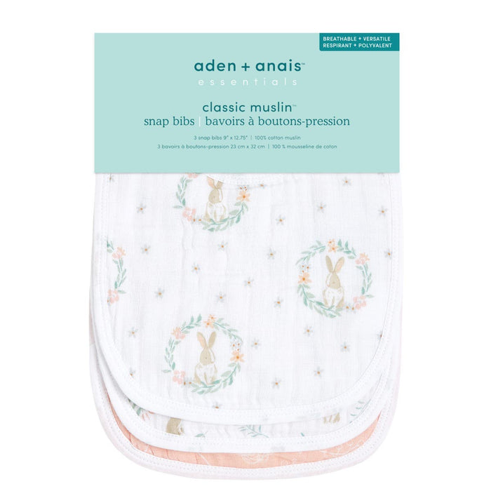 Pack of aden + anais essentials cotton muslin snap bibs, made from absorbent cotton muslin with a cute bunny and floral design. Durable packaging highlights features such as breathability and versatility.
