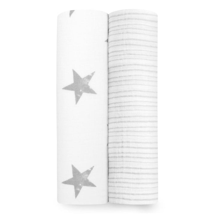 Two essentials cotton muslin swaddle blankets by aden + anais are rolled side by side; the left one has a white background with gray stars, and the right one features thin gray stripes on a white backdrop.