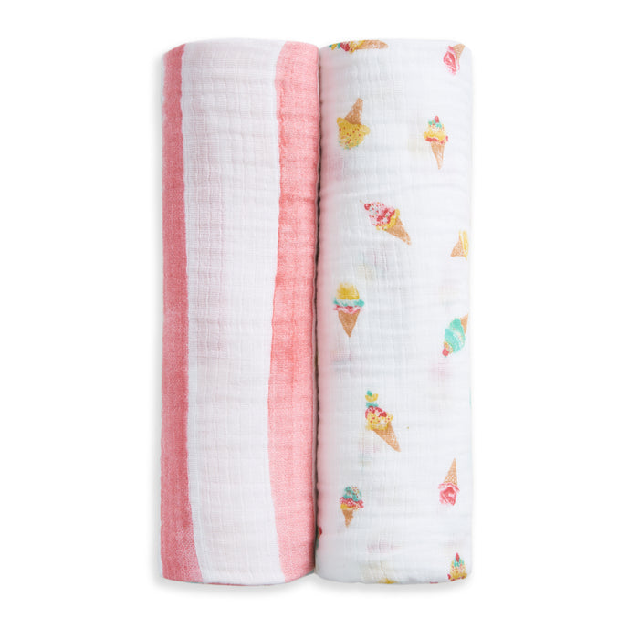 The aden + anais essentials cotton muslin swaddle blanket 2 pack includes one pink and white striped and one ice cream cone print, offering soft, breathable comfort and stylish design for your baby.