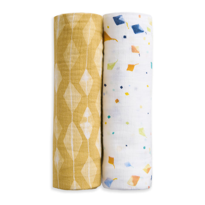The aden + anais essentials cotton muslin swaddle blanket 2 pack - kite includes two soft, breathable blankets: one with a yellow and white geometric diamond pattern, and one white with colorful scattered diamonds in blue, orange, and yellow.