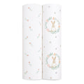 The aden + anais essentials cotton muslin swaddle blanket 2-pack includes two rolled blankets: one with colorful flowers on a white background, and another featuring a rabbit in a floral wreath. Made from soft cotton muslin, they are lightweight and breathable.