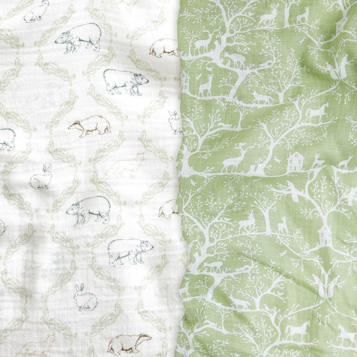 On the left, theres a white cotton muslin with light outlines of bears, bunnies, and deer, while on the right are aden + anais essentials cotton muslin swaddle blankets in green featuring white tree and animal silhouettes like birds, deer, and rabbits.