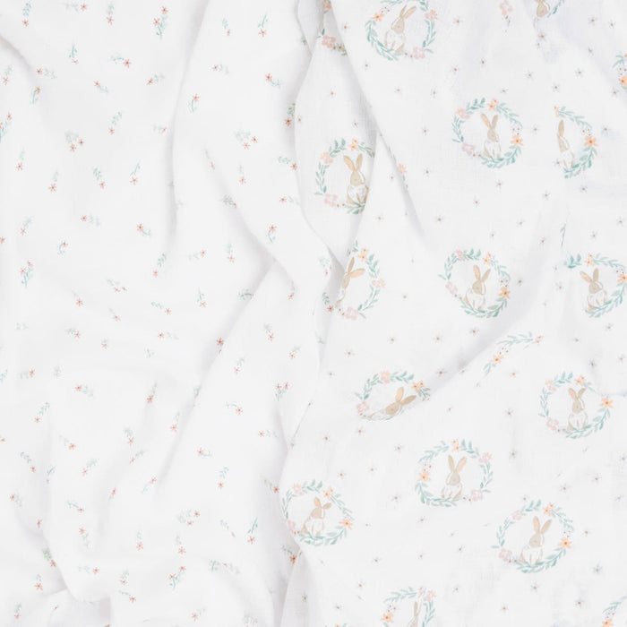 The aden + anais essentials cotton muslin swaddle blanket 2 pack features printed rabbit designs within floral wreaths on a soft, delicate cotton muslin fabric. The predominantly white background and scattered tiny flowers make these blankets perfect for creating breathable swaddles.