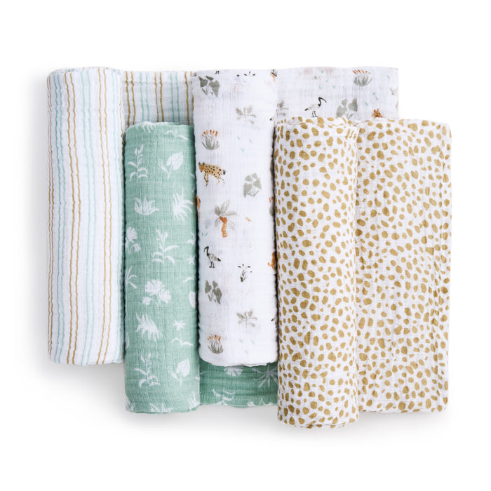 Five rolled-up aden + anais Essentials Cotton Muslin Swaddles are showcased, featuring stripes, green with white floral print, animal illustrations on white, and abstract yellow spots on white. Crafted from soft cotton muslin, they offer comfort and style for your little one.