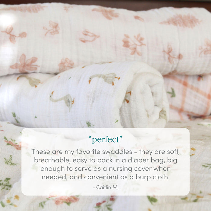 Four soft, cotton muslin swaddle blankets from the aden + anais Disney™ Lilo and Stitch essentials collection are rolled and stacked, with overlaid text showcasing their breathability and versatility—praised by customers for everyday baby care.