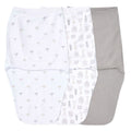 The aden + anais essentials easy swaddle wrap 3 pack features three baby swaddles: one white with small animal prints, a middle one with larger designs, and a solid gray on the right. Designed to prevent startle reflex, these wraps provide a cozy fit for your little ones comfort.