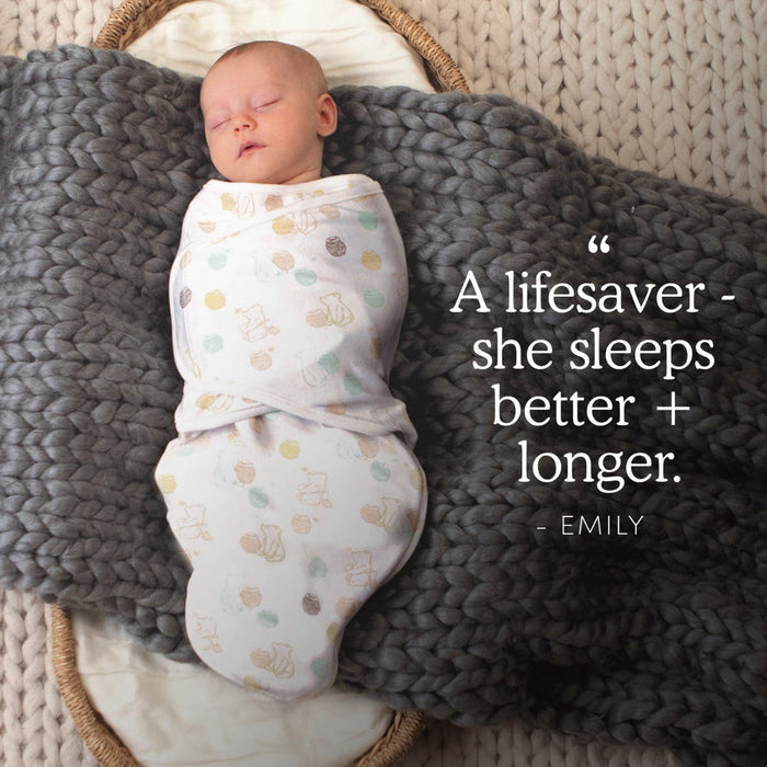 A newborn sleeps peacefully on a chunky gray knit, wrapped in the HALO Disney Winnie the Pooh Bundle. Text beside reads: A lifesaver – she sleeps better + longer. – Emily.