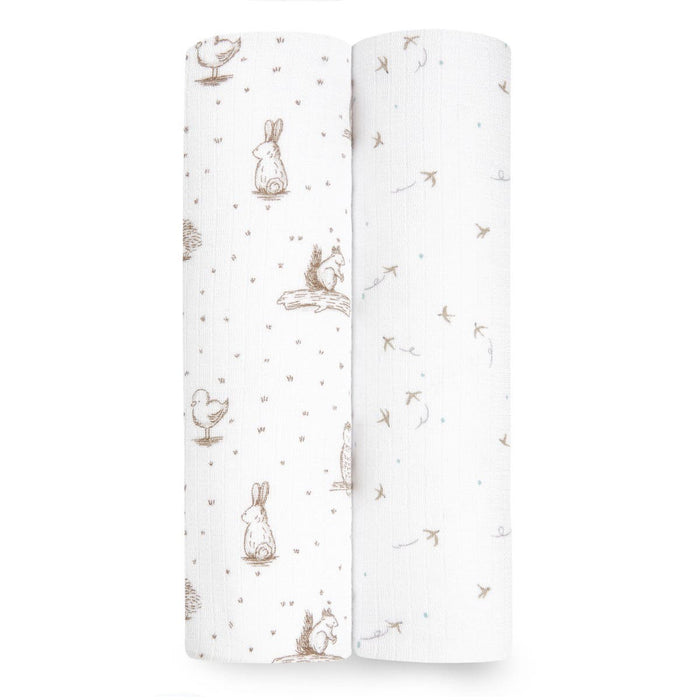 Two rolls of aden + anais essentials silky soft swaddle blankets, ideal for sensitive skin: one with brown animal illustrations and the other with a scattered leaf or twig pattern.