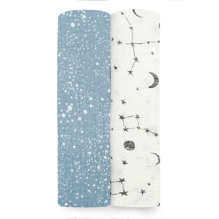 The aden + anais essentials silky soft swaddle blanket 2 pack features two rolls: one bamboo-infused blue with white speckles, and the other white with black moon, star, and constellation patterns. Perfect for a babys sensitive skin, they are displayed side by side on a white background.