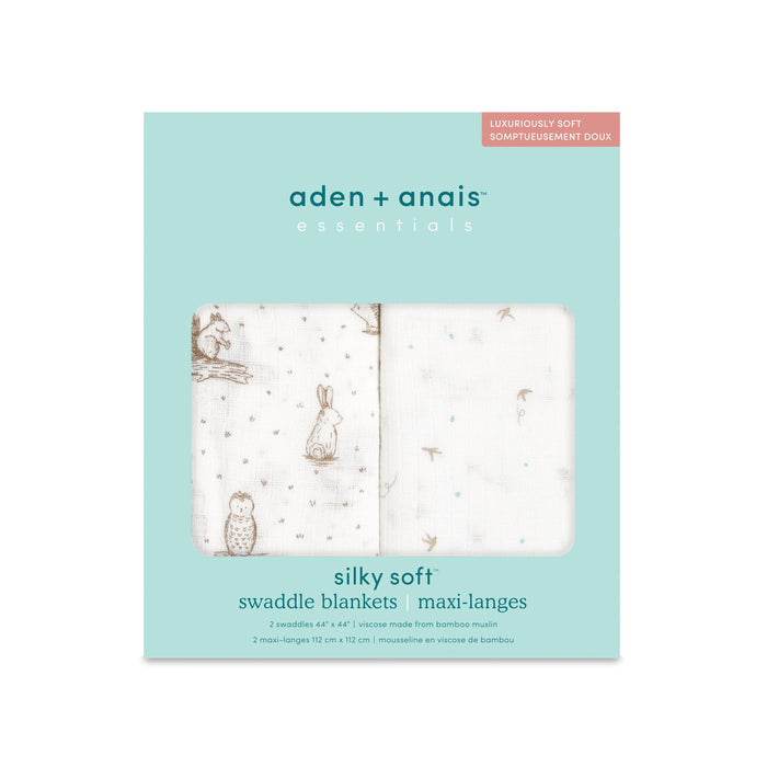 The aden + anais essentials silky soft swaddle blanket 2 pack is ideal for sensitive skin. Light teal packaging contains two bamboo-infused 112 cm x 112 cm swaddles, one with rabbit and owl illustrations, featuring Luxuriously Soft text.