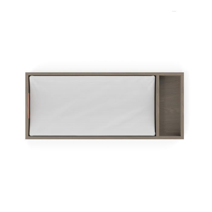 Top view of the Child Craft F01792 Universal Dressing Kit in Crescent Grey, featuring a white checkered mattress and attached open wooden storage, designed to fit a dresser changing topper, shown against a white background.