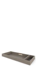 The Child Craft F01792 Universal Dressing Kit in Crescent Grey is a rectangular tray with two compartments, a small leather handle, and a minimalistic design—ideal as a dresser changing topper or for organizing baby essentials.