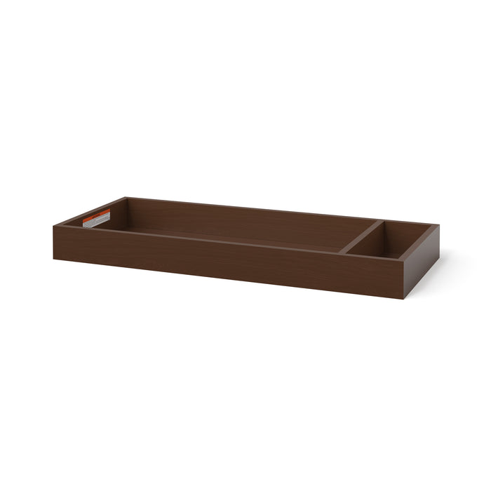 The Child Craft F01792 Universal Dressing Kit in Toasted Chestnut is a rectangular wooden baby changing tray with two compartments, one larger than the other, and features a small label on the inside edge.